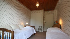 A bedroom with two single beds, a wooden ceiling, and patterned wallpaper. - Cozy Studio in Chantemerle - Sleeps 4, Parking, Balcony, 2 Stars (Saint-Chaffrey)