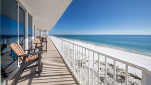 A balcony with wooden chairs, a white railing, and a view of the beach. - West Corner w/Massive Balcony and Spectacular Gulf-Front Views! (Gulf Shores)