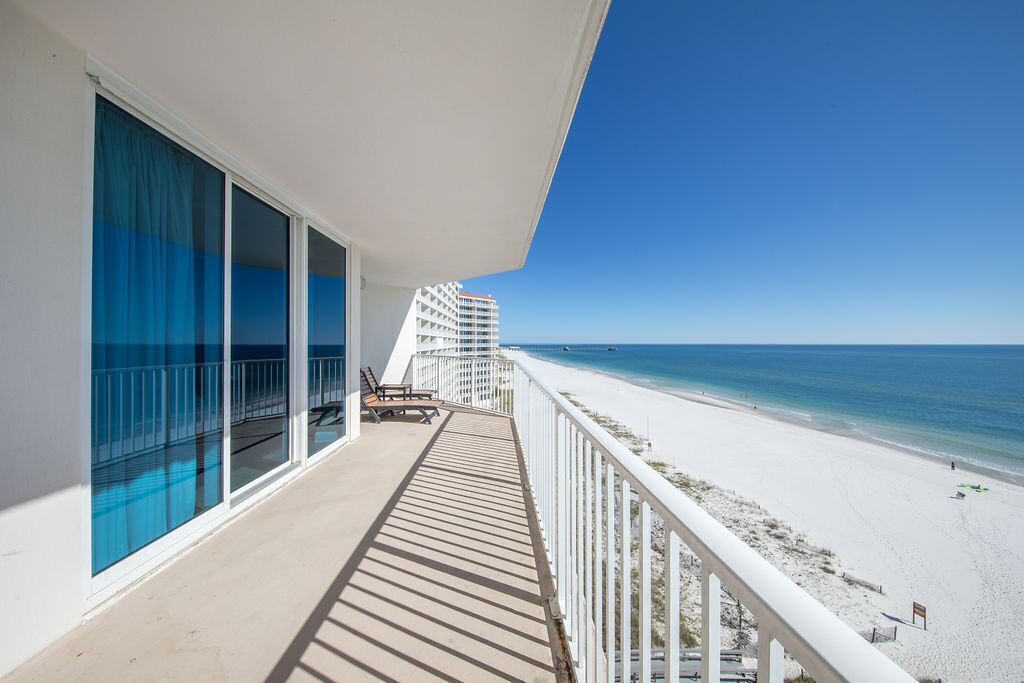 Un balcon avec vue sur la plage et l’océan.