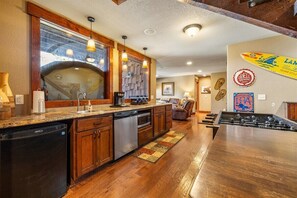 Une cuisine moderne avec des meubles en bois, un lave-vaisselle et un grand îlot central.