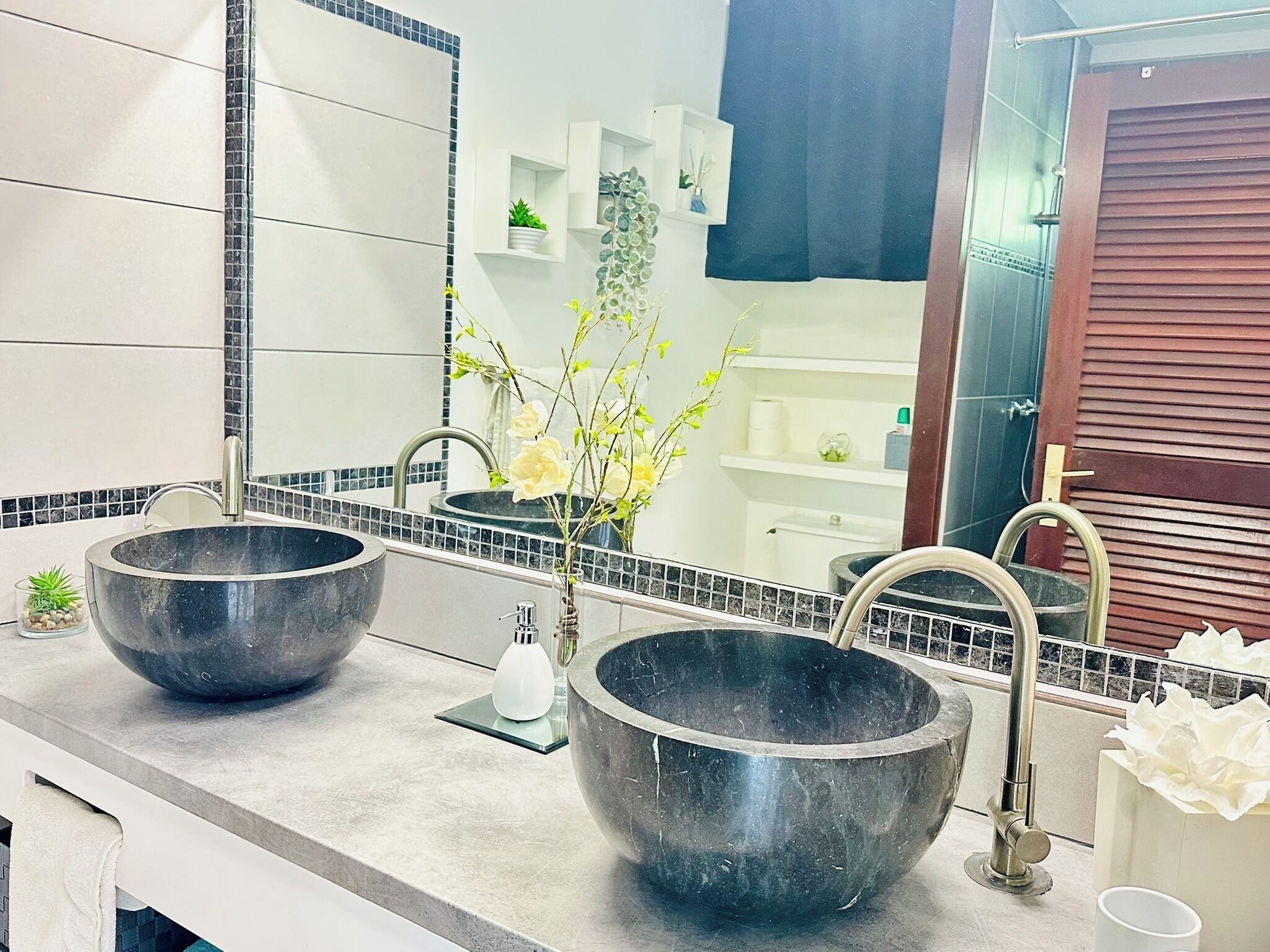 A bathroom with two large black sinks, a white towel, and a mirror.