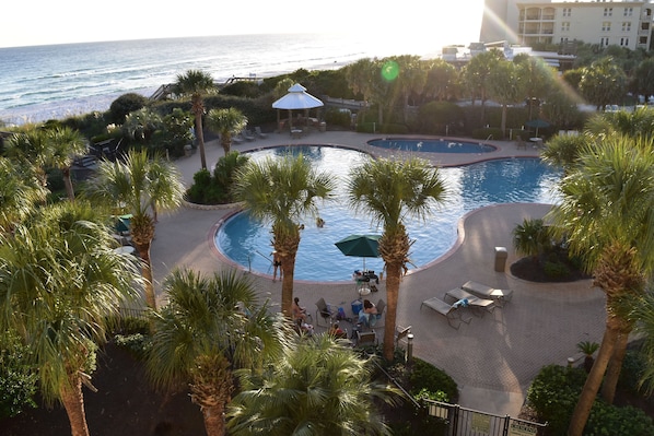 A resort with a pool area, palm trees, and a view of the ocean. - Owner Managed Free Daily Beach Service Included-Platinum Gulf-Front Property (Destin)