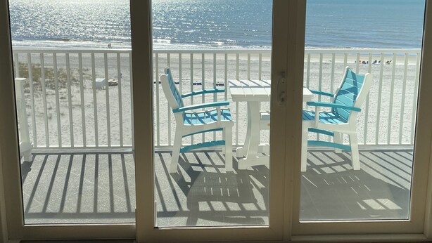 Ein Balkon mit Blick auf Strand und Meer.