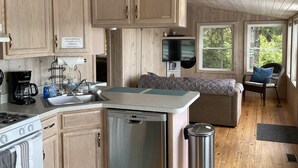 Une cuisine compacte avec des meubles en bois, un lave-vaisselle encastré et une cuisinière.