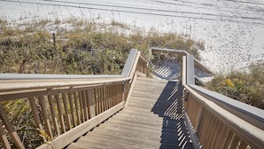 A wooden boardwalk leading to a beach with sand and sparse vegetation. - BEACHFRONT BUILDING l PRIVATE BEACH l GULF GLIMPSE l SEASONAL BEACH SETUP (Santa Rosa Beach)