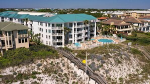A beachfront hotel with multiple balconies, a pool, and a boardwalk. - BEACHFRONT BUILDING l PRIVATE BEACH l GULF GLIMPSE l SEASONAL BEACH SETUP (Santa Rosa Beach)