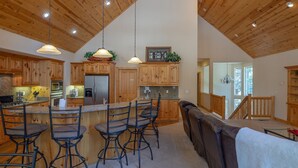A spacious kitchen with wooden cabinets, a central island with bar stools, and pendant lighting. - S. Tahoe Luxury Home, 5 Minutes to Heavenly lodge (South Lake Tahoe)