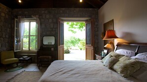 Une chambre à coucher avec un lit, une chaise, un bureau et une fenêtre.