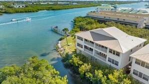 A waterfront hotel with a dock, multiple buildings, and a clear view of the water. - Beautiful Views! Water front! Two Bedrooms and Two Baths with free wifi and beach equipment (Indian Rocks Beach)