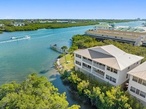 A waterfront hotel with a dock, multiple buildings, and a clear view of the water.