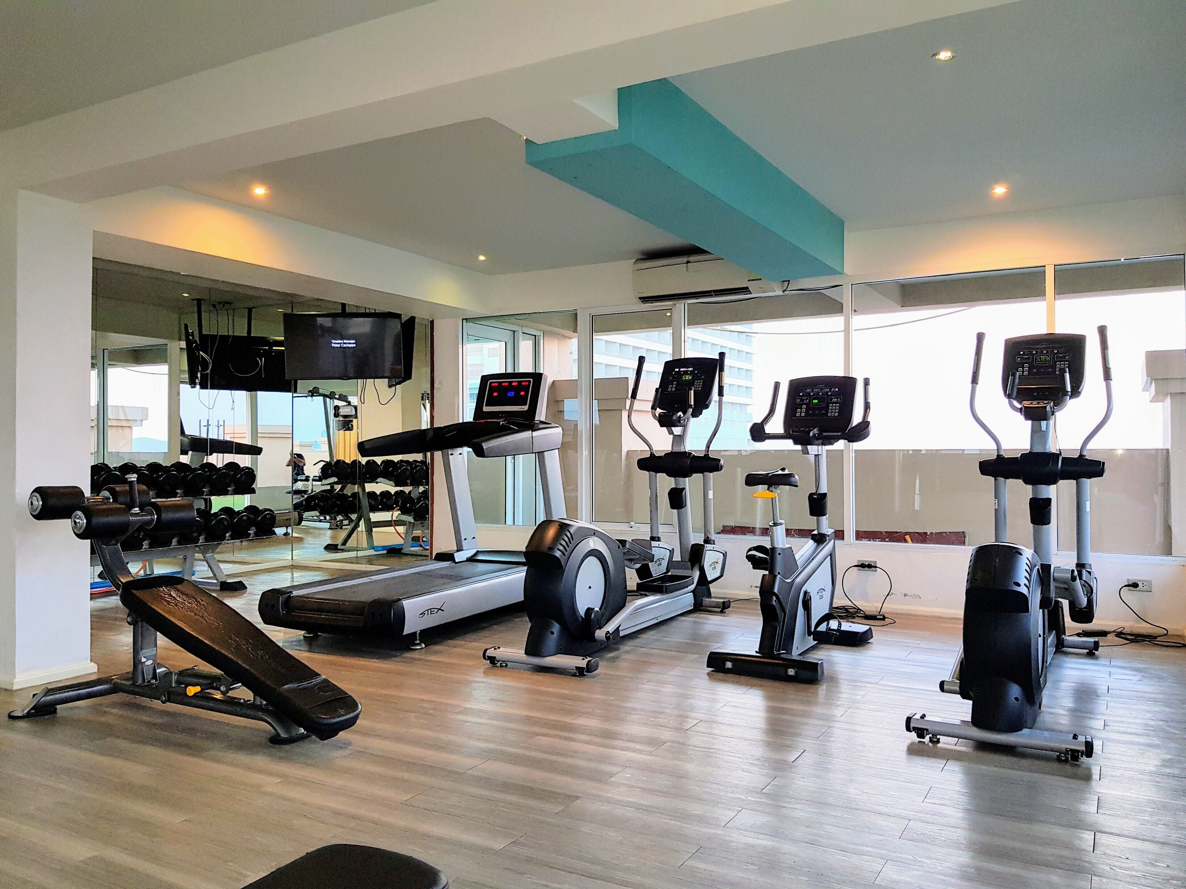 A gym with treadmills, elliptical machines, and free weights.