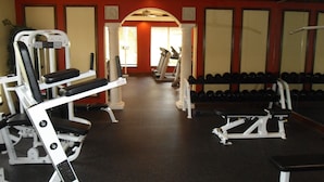 A gym with various exercise equipment, including weight machines and dumbbells. - Large fully furnished, quiet condo with lake view, pool and tennis court (Naples)