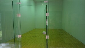 A squash court with green walls and a wooden floor. - Large fully furnished, quiet condo with lake view, pool and tennis court (Naples)