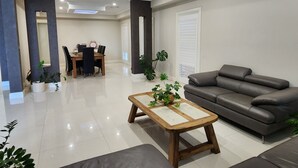 Un salon moderne comprenant un canapé, une table basse et un coin repas avec une table et des chaises.