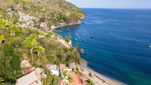 A coastal area with a beach, clear blue sea, and houses with red roofs. - Lux in Yelapa, Infinity Pool, Huge Views, AC, Accommodates 8 to 10 (Yelapa)