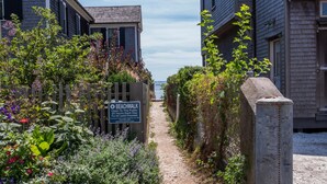 A pathway leading to a beach with a sign indicating a public beachwalk. - Spacious 1 Bedroom, First Fl., Beach Access, in quiet East End. 
 (Provincetown)