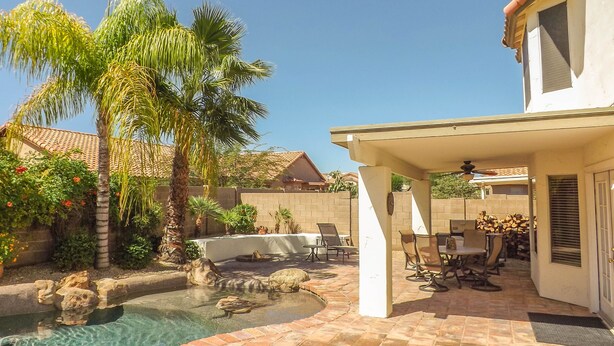 A backyard with a swimming pool, palm trees, and outdoor furniture. - Charming Southwest Style Vacation Home  (Phoenix)