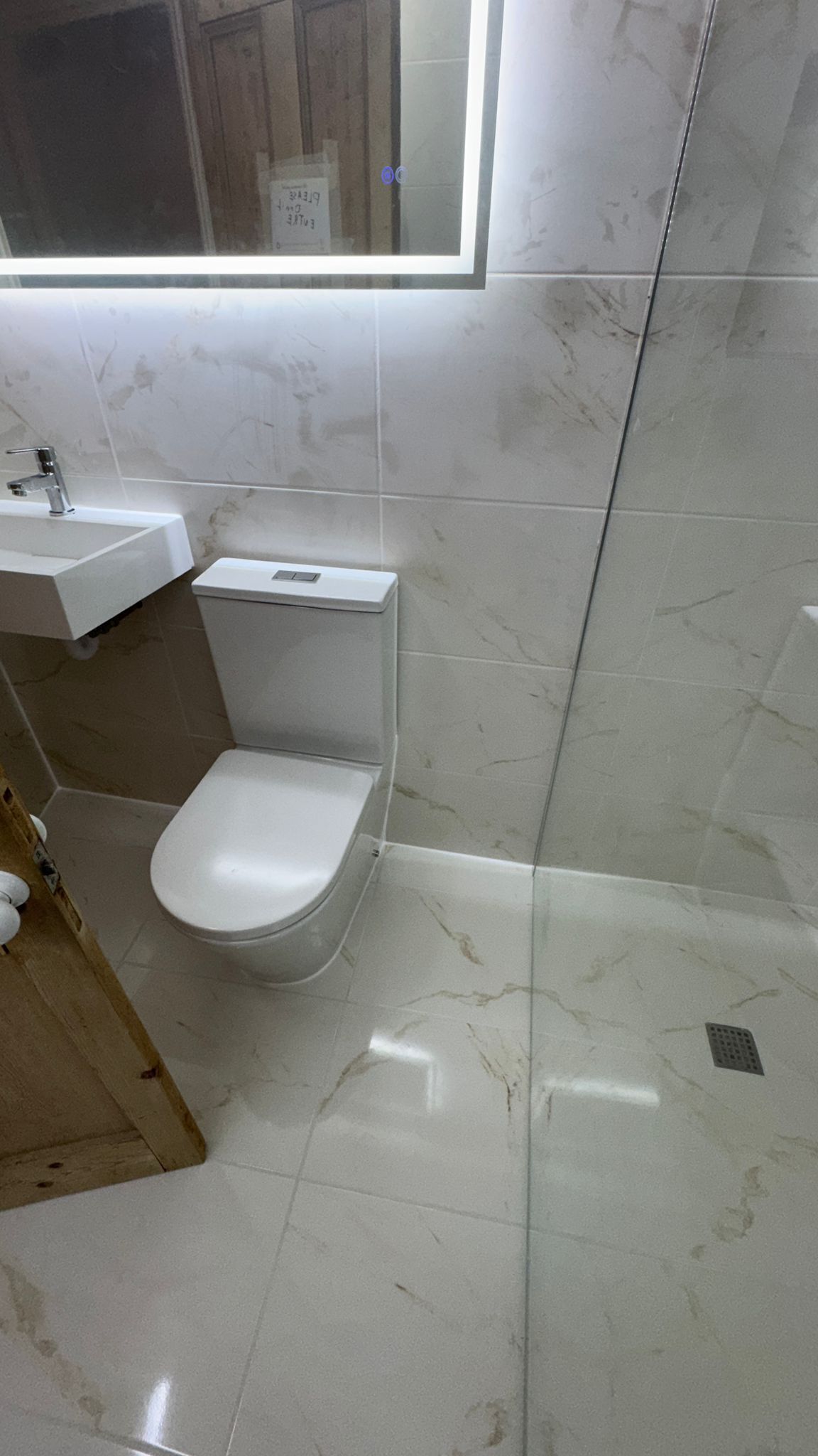 Ein Badezimmer mit Toilette, Waschbecken und Duschbereich.
