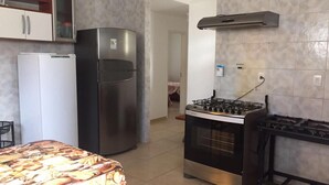 Une cuisine de taille réduite équipée d’un réfrigérateur, d’une cuisinière et d’un four.