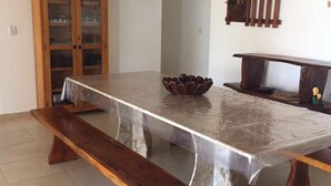 Une table à manger avec un plateau en marbre, des bancs en bois et un bol décoratif posé sur la table.