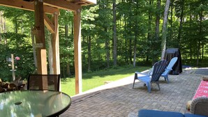 A covered patio with a table and chairs, a grill, and a wooden pergola. - 10 mins. to downtown Saratoga and SPAC. 1,000 sq. ft. Spacious and quiet. (Ballston Spa)