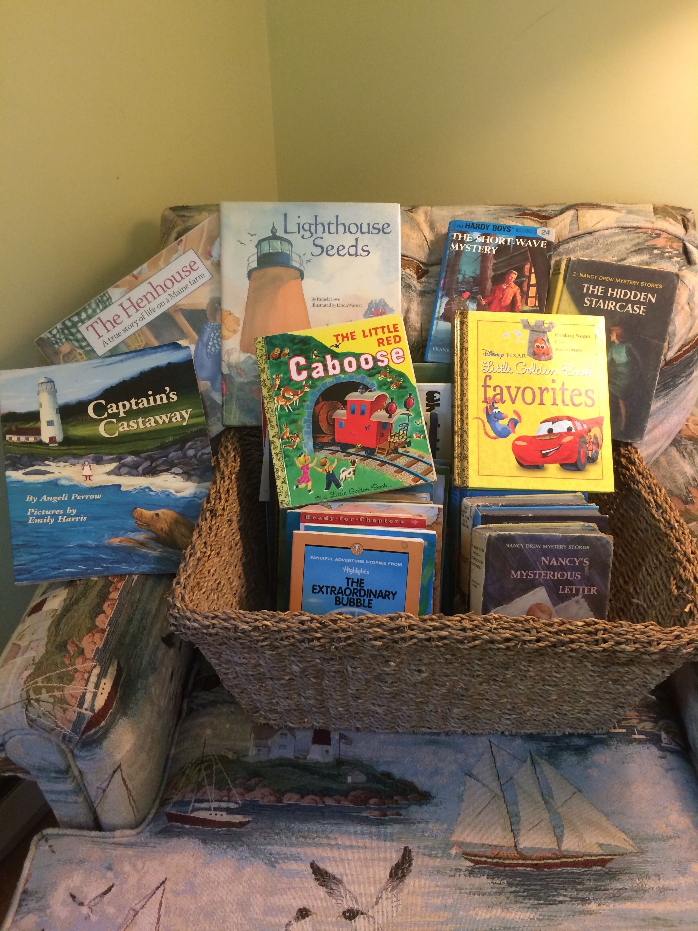 A basket of children's books including titles like "The Little Red Caboose" and "The Extraordinary Bubble".