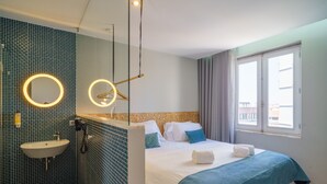 Una habitación de hotel con cama, lavamanos y ventana.