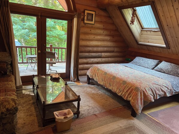 Une chambre dans une cabane en rondins, avec un lit, une table et une chaise.