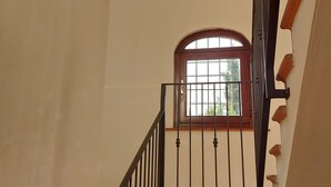 Una scala con ringhiera in metallo, una finestra con cornice in legno e un muro a mattoni.