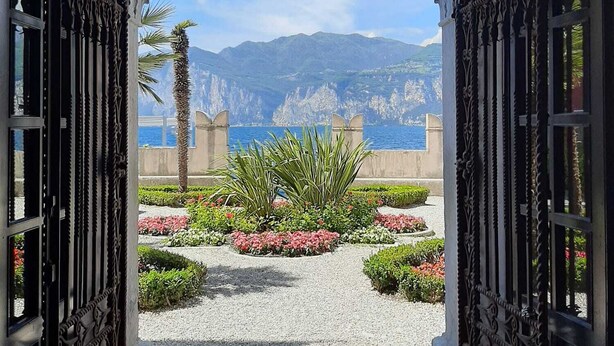 An ornate archway leading to a garden with a view of mountains and the sea. - Villa on LAKE with private dock.  (BRENZONE SUL GARDA)