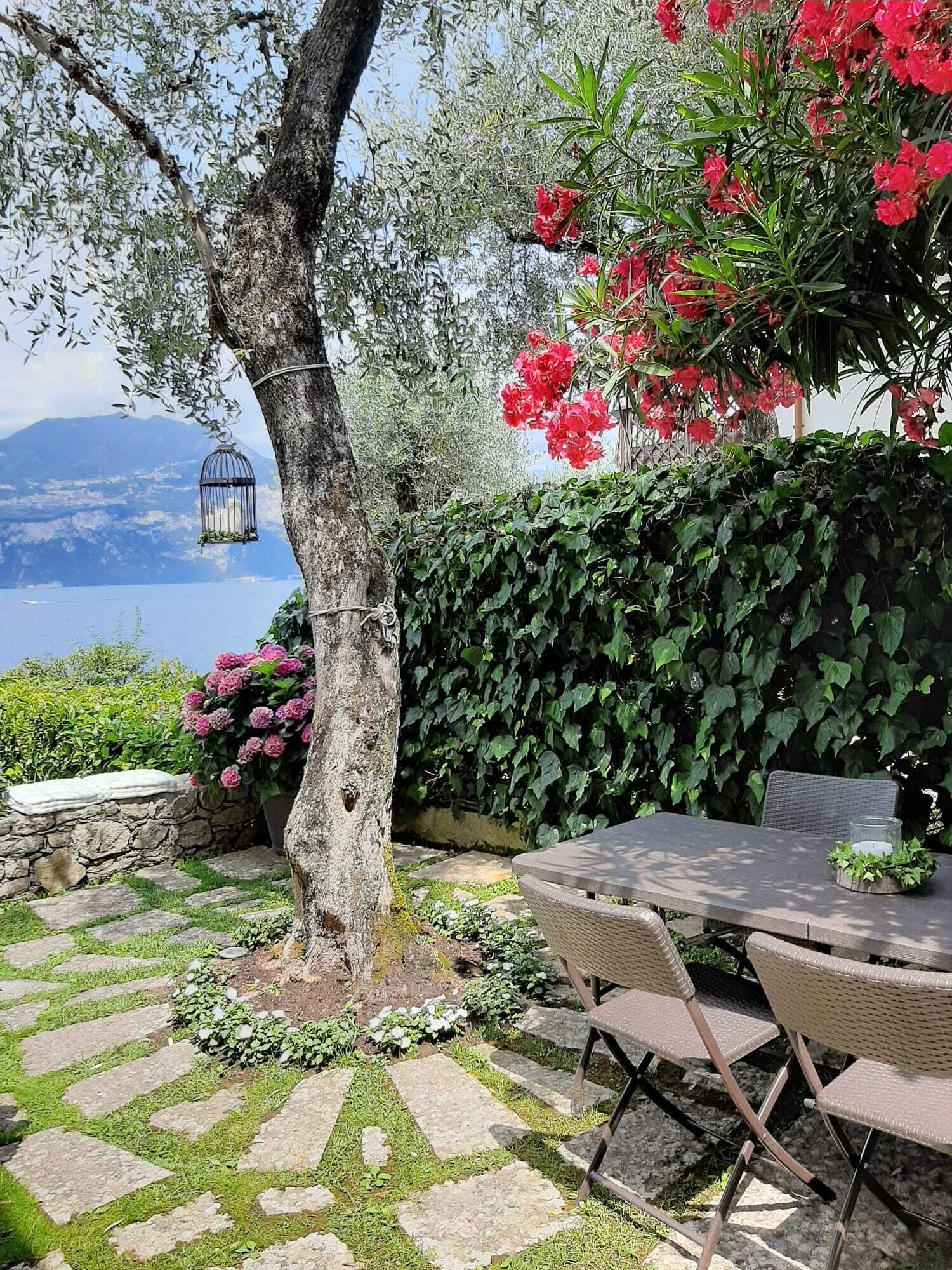 Eine Terrasse mit Steinboden, einem Tisch und Stühlen.