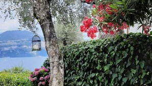 A patio with a stone floor, a table, and chairs. - Villa on LAKE with private dock.  (BRENZONE SUL GARDA)