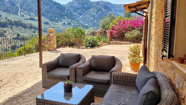 A covered patio with wicker furniture and a view of mountains. - Beatiful and peaceful villa with amazing views into the mountains  (Sóller)
