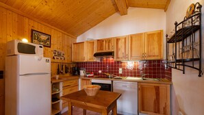 Una cocina con armarios de madera, microondas, fregadero y una mesa con un tazón.