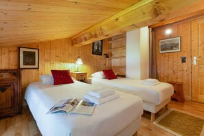 Eine Holzhütte mit zwei Betten, einem Nachttisch mit Lampe und einem gerahmten Bild an der Wand.