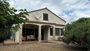 A house with a covered patio, a satellite dish, and a garden with plants and flowers. - Spacious Villa with large private Pool and Air-conditioning in all 5 bedrooms (Les Aires)