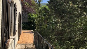 A narrow pathway leading to a building with a brick facade and metal shutters. - Spacious Villa with large private Pool and Air-conditioning in all 5 bedrooms (Les Aires)