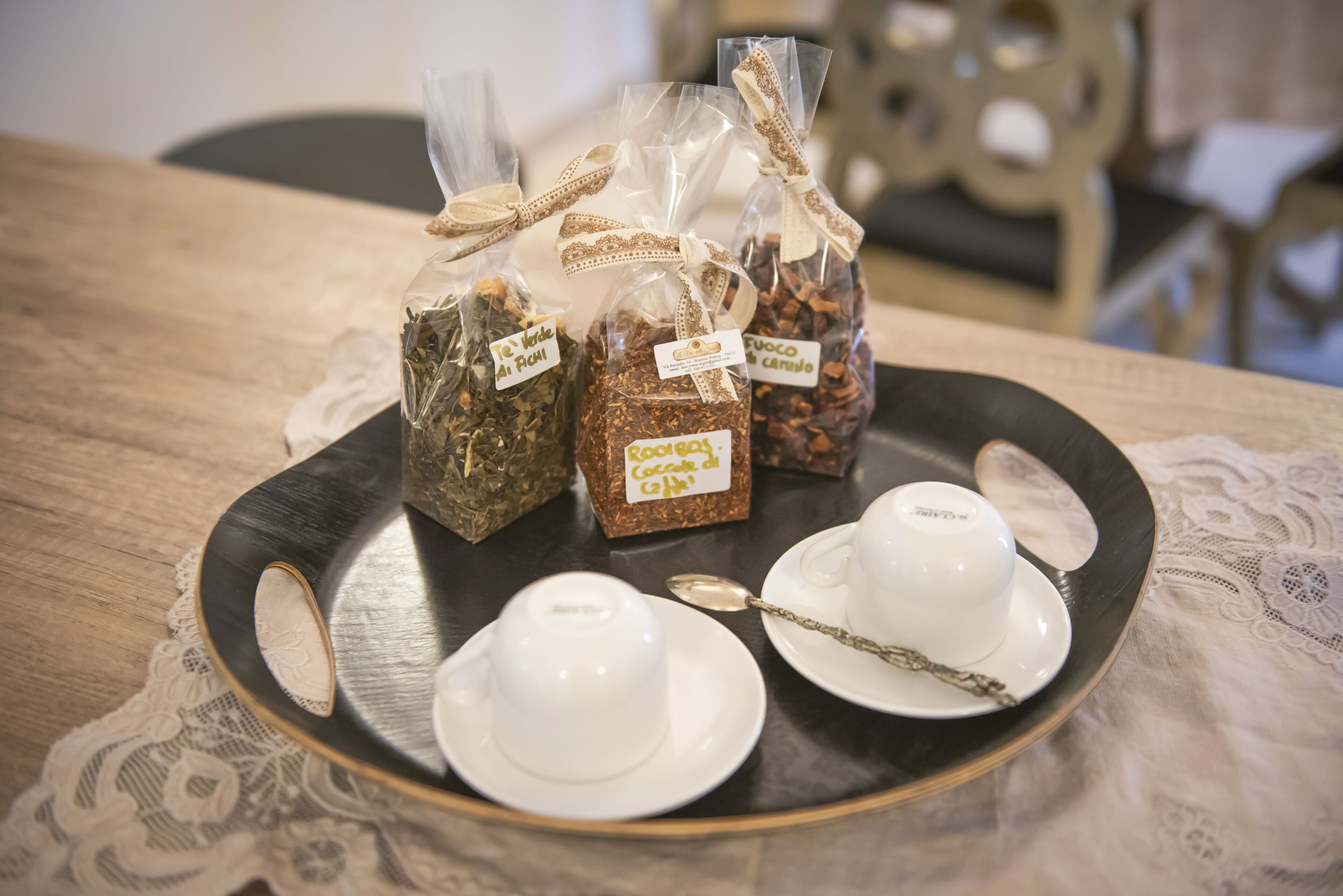 A tray with tea bags and teacups on a table.