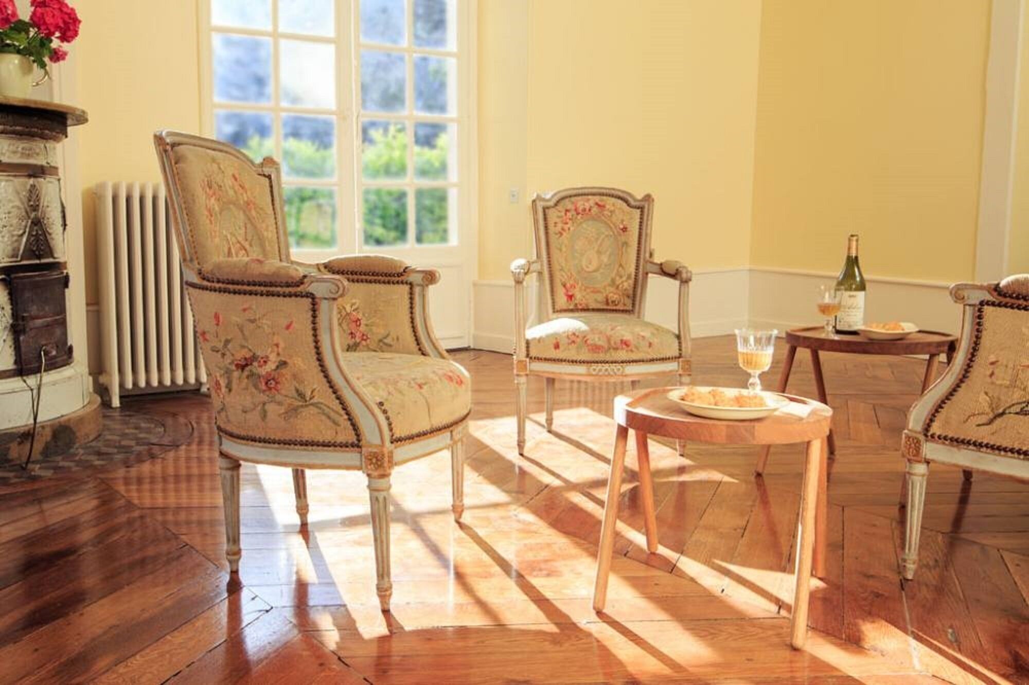 A room with two upholstered chairs, a small round table, and a radiator.
