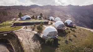 Varias estructuras de cúpulas geodésicas en una ladera con cielo despejado.