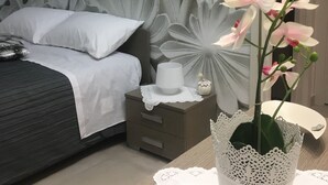 Une chambre à coucher comprenant un lit, une table de chevet et un panneau décoratif mural.