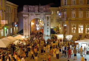 A crowded square with an ancient archway, surrounded by buildings. - large villa with pool and spa (Pomer)