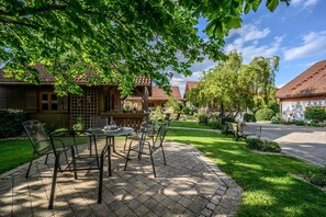 A patio with outdoor furniture, a wooden fence, and a well-maintained lawn.