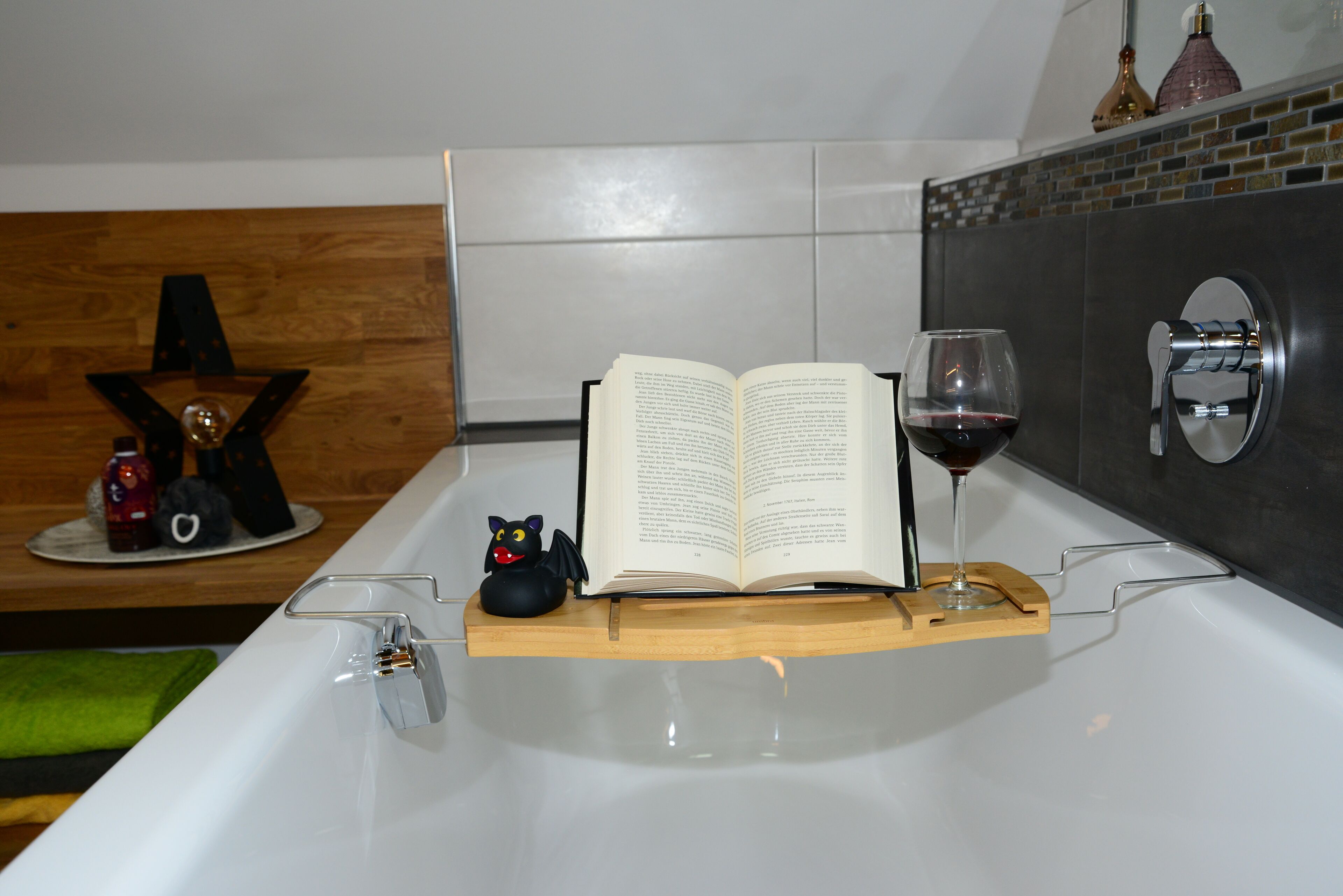 Une baignoire, un livre ouvert et un verre de vin.