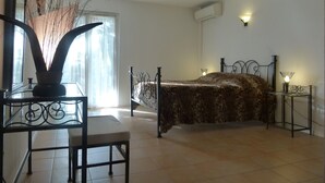 A bedroom with a bed, a chair, a table, and a window with curtains. - Sun holidays in the calm of the French Riviera. 3 *** apartment (Les Adrets-De-L'estérel)