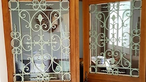 A wooden door with intricate metal designs and glass panels. - Apartment Le Solutré (Chardonnay)