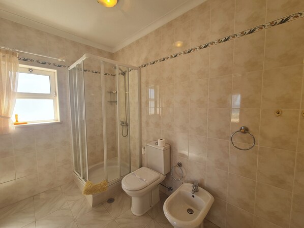 A bathroom with a glass-enclosed shower, a toilet, and a bidet. - Apartment with Stunning Sea View & Private Rooftop, 300m to Beach (Lagos)