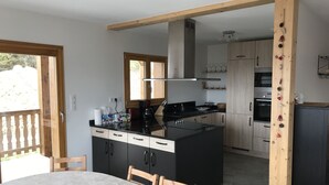 Une cuisine moderne dotée d’un îlot central, de meubles en bois et d’un coin repas avec une table et des chaises.
