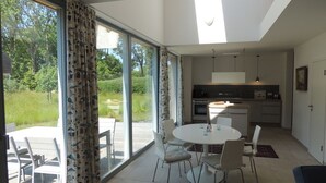 Una cocina moderna con comedor, ventanas amplias y tragaluces.