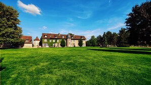 A large, historic building with a spacious lawn in front. - CHARMING RESIDENCE with swimming pool and indoor spa (Conches-en-Ouche)